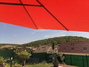 ein roter Regenschirm vor einem Haus in der Unterkunft Maison familiale in Follainville-Dennemont