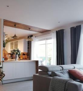 ein Wohnzimmer mit Couch und Küche in der Unterkunft Maison familiale in Follainville-Dennemont