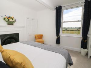 a bedroom with a bed and a fireplace and a window at Chestnuts at Youlton Lodge in York