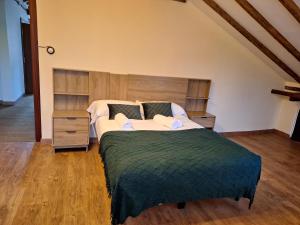 a bedroom with a large bed with a green blanket at Parque Remonta in Santander