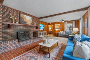 a living room with a brick fireplace and a blue couch at Spacious Family Home - 10 Mins to Cartersville in Cartersville