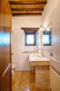 a bathroom with a sink and a toilet and a mirror at Castello di Cisterna in Cisterna