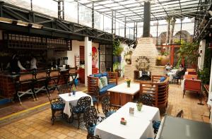 a restaurant with tables and chairs and a fireplace at Hacienda Valentino in San Cristóbal de Las Casas