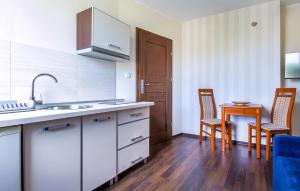a kitchen with a sink and a table and chairs at Gorgeous Apartment In Jastarnia in Jastarnia