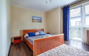 a bedroom with a bed and a large window at Gorgeous Apartment In Jastarnia in Jastarnia