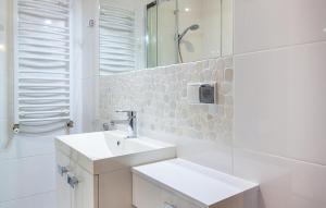 a white bathroom with a sink and a mirror at Gorgeous Apartment In Jastarnia in Jastarnia