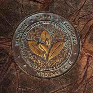 a metal coin with a flower on it on a table at Inhouse Hotel Taichung in Taichung