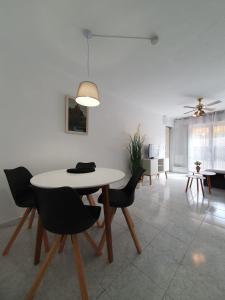 Un comedor con una mesa y sillas blancas. en Casa Victor, en San Pedro del Pinatar