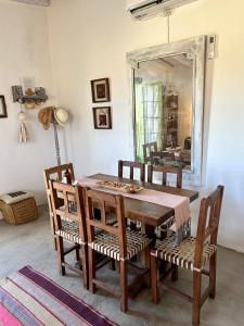Una mesa de comedor con sillas y un espejo. en Casa San José, en Cachí