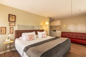 a bedroom with a large bed and a red couch at Hotel Living 55 in Bogotá