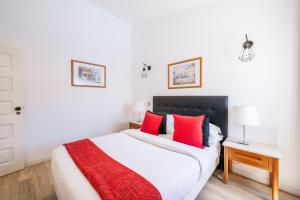a bedroom with a large bed with red pillows at Monte Sao Pedro - Villa in Luz +21 photos