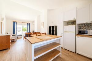 a kitchen and dining room with white cabinets and a table at Monte Sao Pedro - Villa in Luz