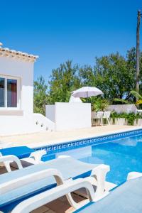 a villa with a swimming pool and chairs at Monte Sao Pedro - Villa in Luz