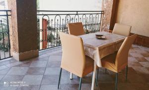 a table and chairs with a table and a balcony at Il Centro in Tergu