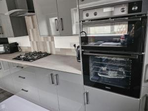 a kitchen with a stove and an oven at Jubilee Jem in Aberaman +14 photos