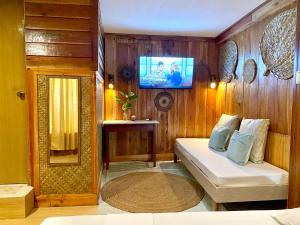 a room with a bed and a tv on a wall at Bohol Island Homestay in Dauis