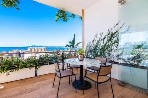 a table and chairs on a balcony with a view of the ocean at SOHO PV - 1007 Best and Brand New Condo in Puerto Vallarta