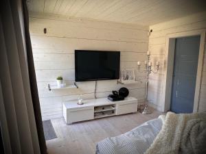 ein Wohnzimmer mit einem Flachbildfernseher an der Wand in der Unterkunft Almbacka gård in Kävlinge