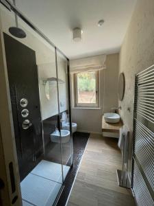 un bagno con due lavandini e una doccia in vetro di La BouganVillea a Francavilla al Mare Altre 37 foto