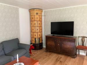 a living room with a couch and a flat screen tv at Newly renovated cozy house Urshult-Åsnen-south Småland in Urshult