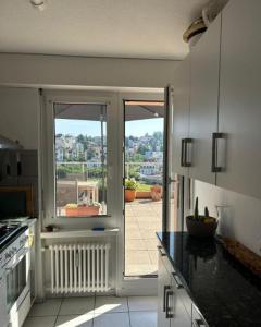 a kitchen with an open door to a patio at Rooftop ink Parking in Lucerne