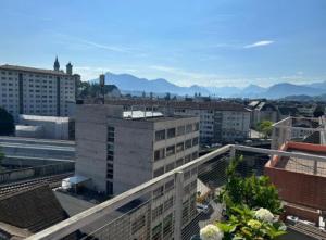 a view of a city with buildings and mountains at Rooftop ink Parking in Lucerne
