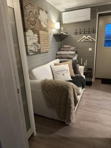 ein Zimmer mit einem weißen Bett, Decken und Kissen in der Unterkunft Almbacka gård in Kävlinge