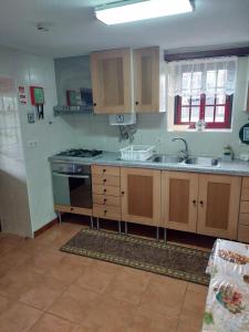een keuken met een spoelbak en een fornuis bij SERRADO Da EIRA in Lajes das Flores +28 foto's