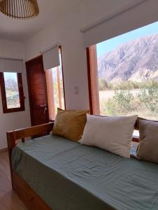 a bedroom with a bed with a view of a mountain at El Alfarero de Maimará in Maimará