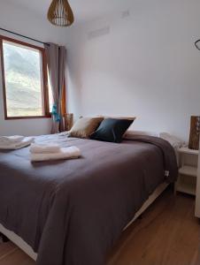 a bedroom with a large bed with towels on it at El Alfarero de Maimará in Maimará