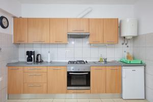 a kitchen with wooden cabinets and a stove top oven at Apartment Tisno 4295a in Tisno +23 photos