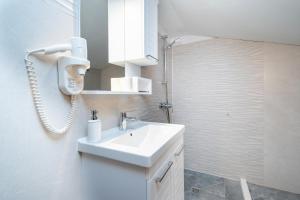 a white bathroom with a sink and a shower at Family friendly house with a swimming pool Radovin, Zadar - 21307 in Ražanac +15 photos