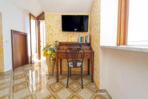 a desk in a room with a television on a wall at Villa Incoronata in Agerola