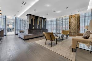 a living room with a couch and a table and chairs at Deluxe 1BR Suite with bird's eye CN Tower Views in Toronto