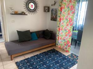 Una sala de estar con un sofá en una habitación. en Le Ti Coin à Didy, en Fort-de-France