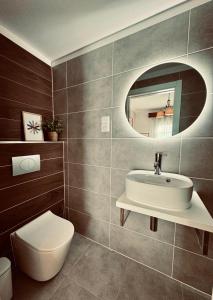 a bathroom with a sink and a toilet and a mirror at A casa do Boubelo in Vimioso