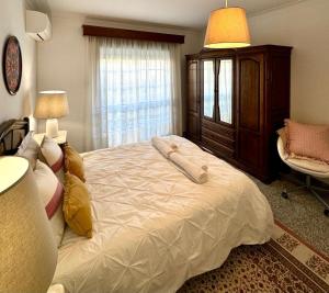 a bedroom with a large bed and a window at A casa do Boubelo in Vimioso