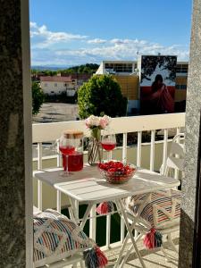 a table with two glasses of wine on a balcony at A casa do Boubelo in Vimioso