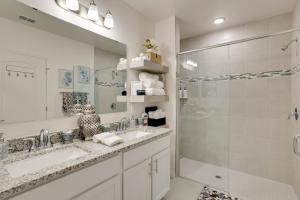 a white bathroom with two sinks and a shower at Beautiful Port St Lucie Home with Hot Tub! in Port Saint Lucie +20 photos