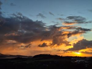 a cloudy sky with the sun setting in the background at La plus belle vue de Ducos ! in Ducos