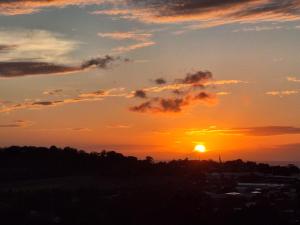 a sunset with the sun setting over a city at La plus belle vue de Ducos ! in Ducos