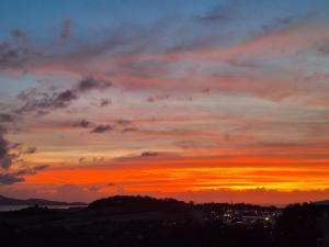 a sunset in the sky over a city at La plus belle vue de Ducos ! in Ducos
