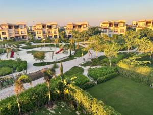 an aerial view of a park with palm trees and condos at Twin House At Marassi Veneto in Sīdī ‘Abd ar Raḩmān