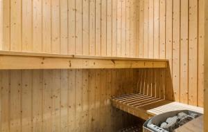 a sauna with wooden walls and a wooden shelf at Awesome Home In Ebeltoft With Sauna in Ebeltoft
