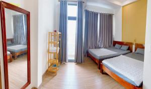a bedroom with two twin beds and a mirror at TRI'S Homestay in Quy Nhon