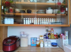 a glass cabinet with bowls and other items on it at Akitsuki Kominka Yado You in Asakura