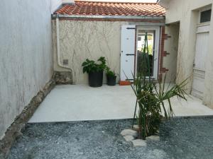 a patio with a door and two potted plants at Maison rénovée 2 ch, terrasse, proche plage et centre, parking, équipements complets, animaux ok - FR-1-22-356 in La Tranche-sur-Mer