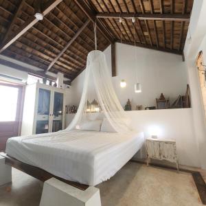 a bedroom with a large white bed with mosquito net at The Hip House Villa Phuket in Ban Bang Khu