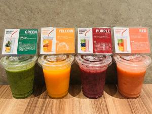 a group of different colored drinks in jars on a counter at The BREAKFAST HOTEL PORTO Ishigakijima in Ishigaki Island