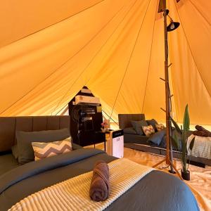tenda con letto e divano in camera di Glamping Wetland Putrajaya a Putrajaya
